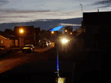 a row of cars are parked on the side of a street at night