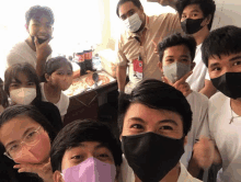 a group of people wearing face masks posing for a photo