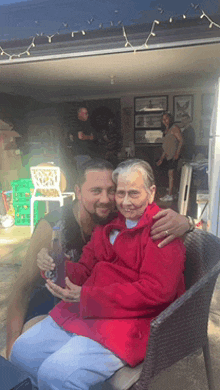 a man hugging an older woman in a red jacket