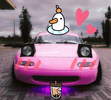 a pink car with a duck on top and a cup of tea