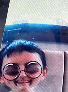 a close up of a child wearing glasses and making a face