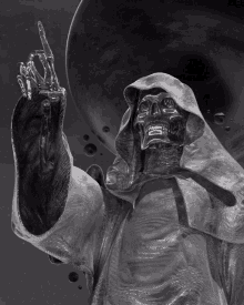 a statue of a grim reaper in a hooded robe giving the middle finger