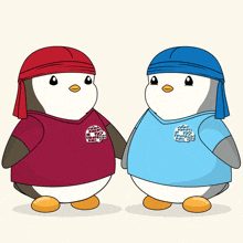 two penguins wearing red and blue shirts with an igloo on the front