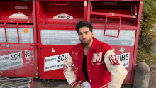 a man wearing a red jacket with the letter m on the sleeve