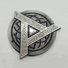 a belt buckle with a celtic knot design and a triangle in the middle .