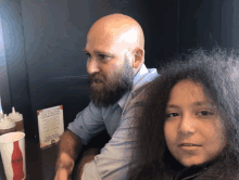 a man and a girl sit at a table with a coca cola bottle on it