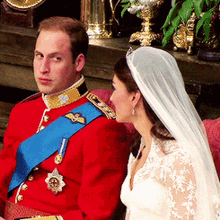 a man in a red uniform with a blue sash around his waist is sitting next to a woman in a white dress