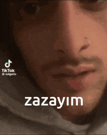 a close up of a man 's face with the words zazayim on the bottom right