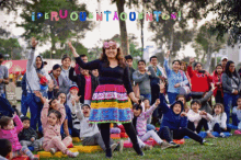 a woman in a colorful skirt stands in front of a crowd of people with the words peru cuentacuentos written above her