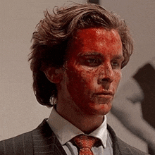 a man in a suit and tie is covered in blood .