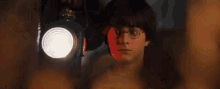 harry potter is standing in front of a spotlight .
