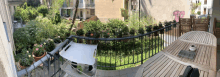 a balcony with lots of potted plants and a table and chair