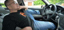 a man is sitting in a car with his foot on the wheel