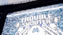 a large screen displays the words trouble shooter on it