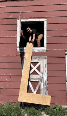 a man is holding a large l in front of an old barn