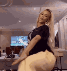 a woman in a black shirt is dancing in a living room .