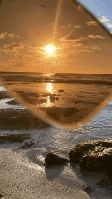 a sunset over the ocean is seen through sunglasses