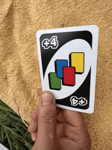 a person is holding a uno card that has the number 4 on it