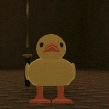 a yellow duck with orange legs is standing on a wooden floor in a dark room .