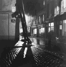 a black and white photo of a street with a sign that says rue le faubourg on it