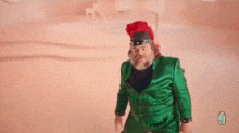 a man with a beard is wearing a green suit and a red helmet .