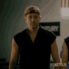 a man in a karate uniform is standing in front of a sign that says netflix