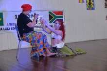 two women dancing in front of a sign that says africa on it