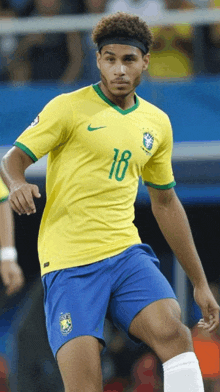 a soccer player wearing a yellow shirt with the number 18