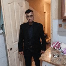 a man in a suit is standing in front of a door with a pack of cigarettes on the counter