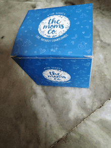 a blue box that says " the moms co " on it