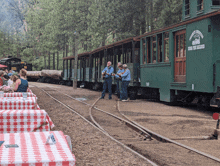 a group of people are standing in front of a train that says sierra nevada railway