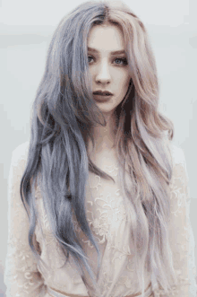 a woman with long blue and pink hair is wearing a white dress