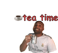 a man wearing a fly emirates shirt holds a cup of tea