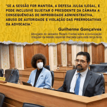 a man in a suit sits at a desk with a sign that says " guilherme gonçalves "