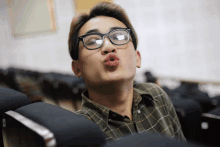 a man wearing glasses is making a funny face with his mouth open