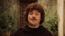 a man with curly hair and a mustache is making a face