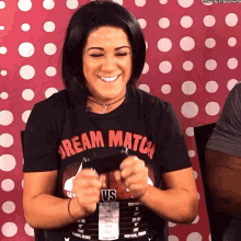 a woman wearing a shirt that says dream match vs