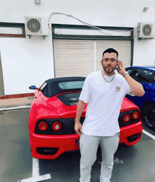 a man standing in front of a red car that says ferrari on the back