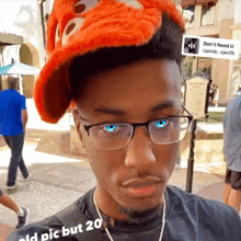 a man wearing glasses and a hat with a sign behind him that says " do n't need u "