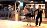 a man and a woman are dancing on a dance floor while people watch .