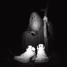 a black and white photo of a wizard with a cane and a pair of jordan shoes