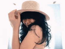 a woman with long black hair is wearing a hat