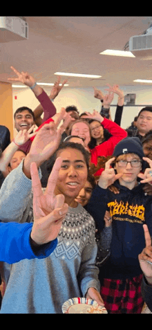 a group of people are posing for a picture and one of them is wearing a thrasher hoodie