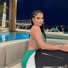 a woman in a green dress sits at a table