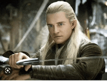 a man with long blonde hair is holding an arrow