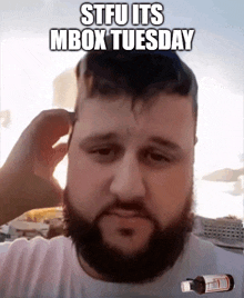 a man with a beard has a bottle of medicine on his head and the words stfu its mbox tuesday above him