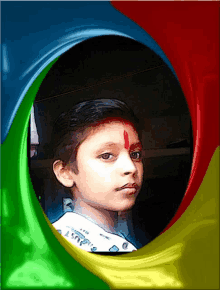 a young boy with a red dot on his forehead wears a white shirt with the word angry on it