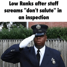 a police officer salutes in front of a wooden fence and says low ranks after staff