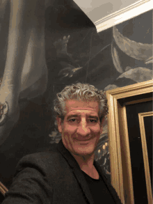 a man taking a picture of himself in front of a painting