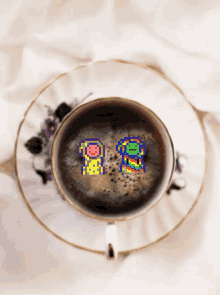 a cup of coffee on a saucer with two pixel art characters in it